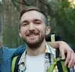 Two friends smiling during a forest hike, enjoying nature and friendship.